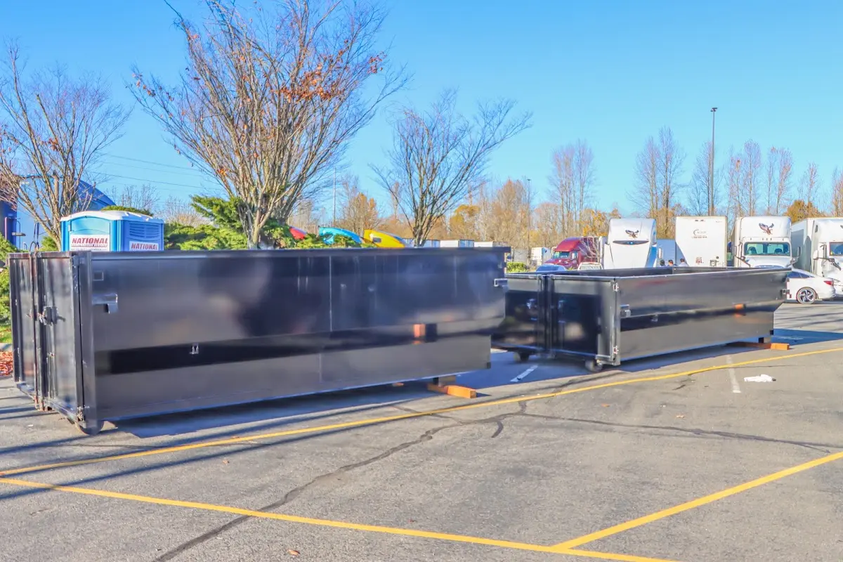 Professional dumpster rental service with roll-off container on residential driveway in Mont Belvieu